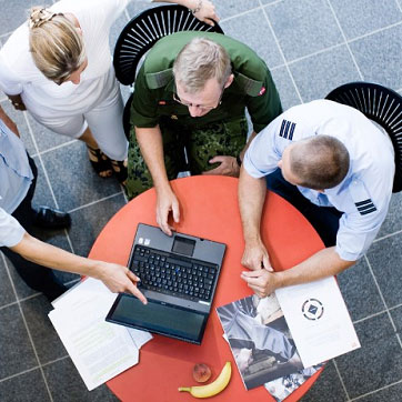 Billedet forestiller nogle ansatte i Forsvaret - både civile og militæransatte i uniform.